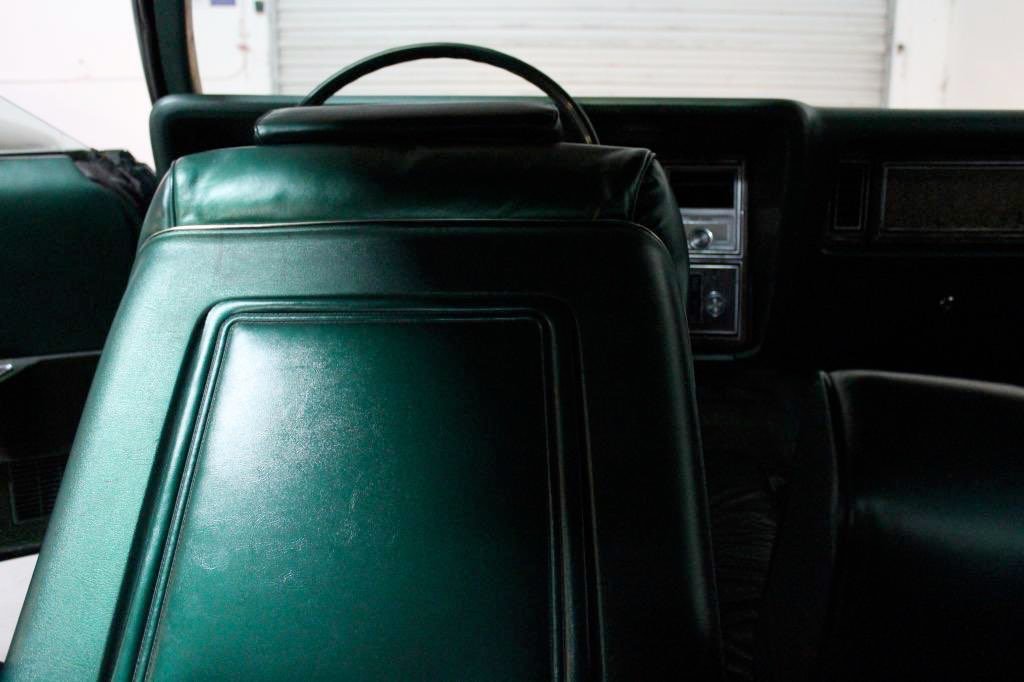 Interior of a vehicle showing green leather seats and dashboard.