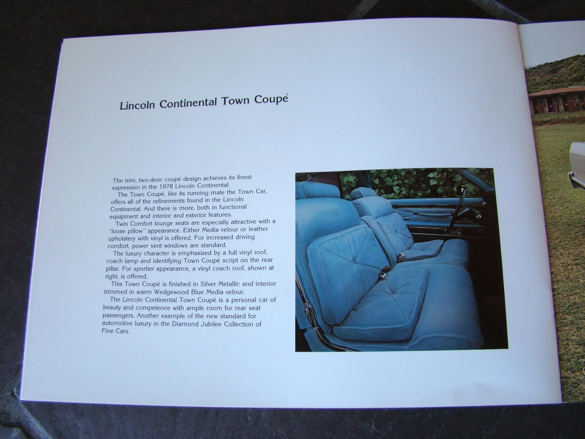 Open book with description of a 1978 Lincoln Continental Town Coupe and a photo of the car's blue interior with seats and dashboard