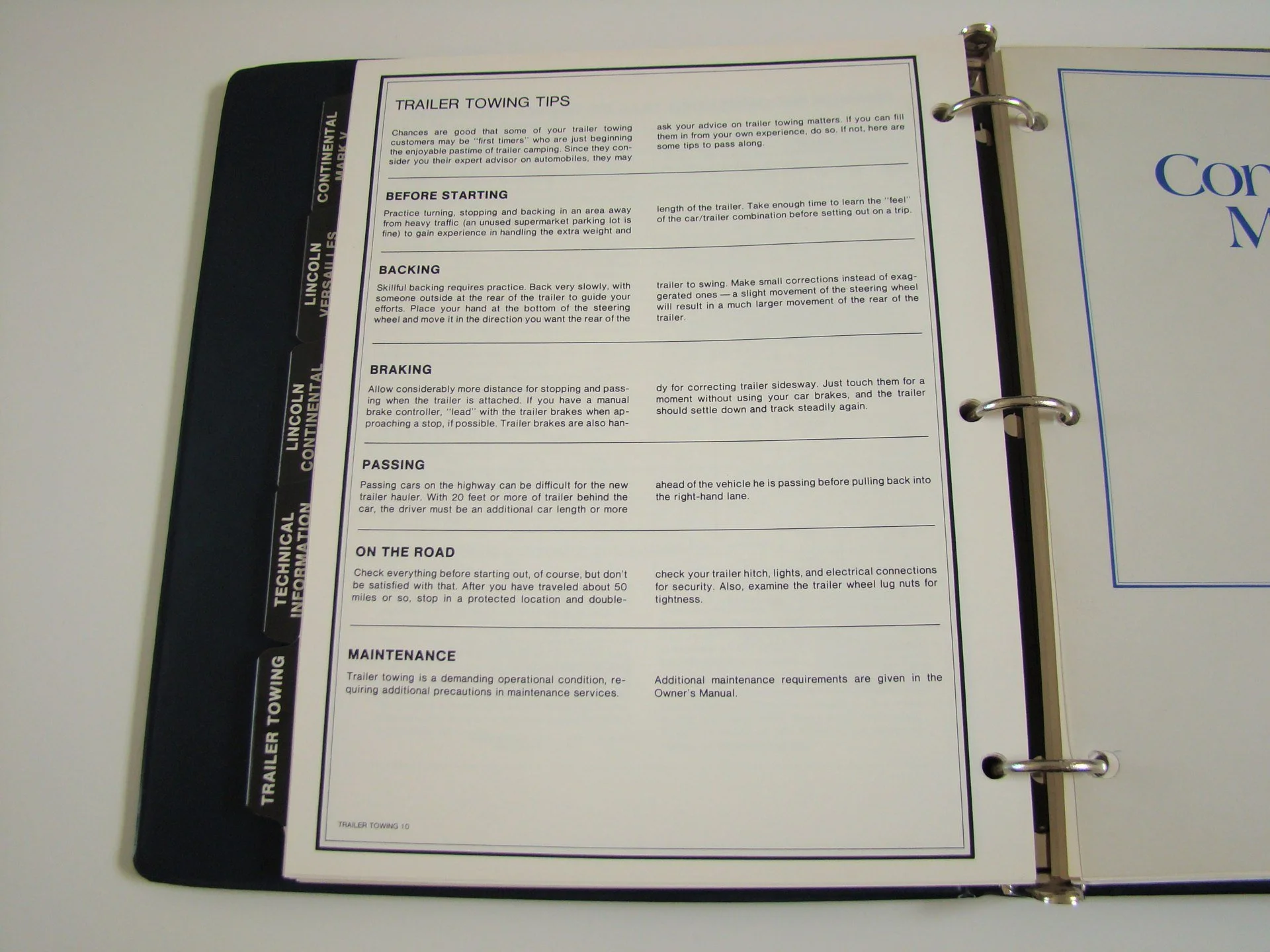 Page with tips for trailer towing, including sections for starting, backing, braking, passing, on the road, and maintenance, in a binder with a black spine labeled 'Lincoln Continental'