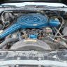 Close-up of a car engine with blue components and metallic parts.