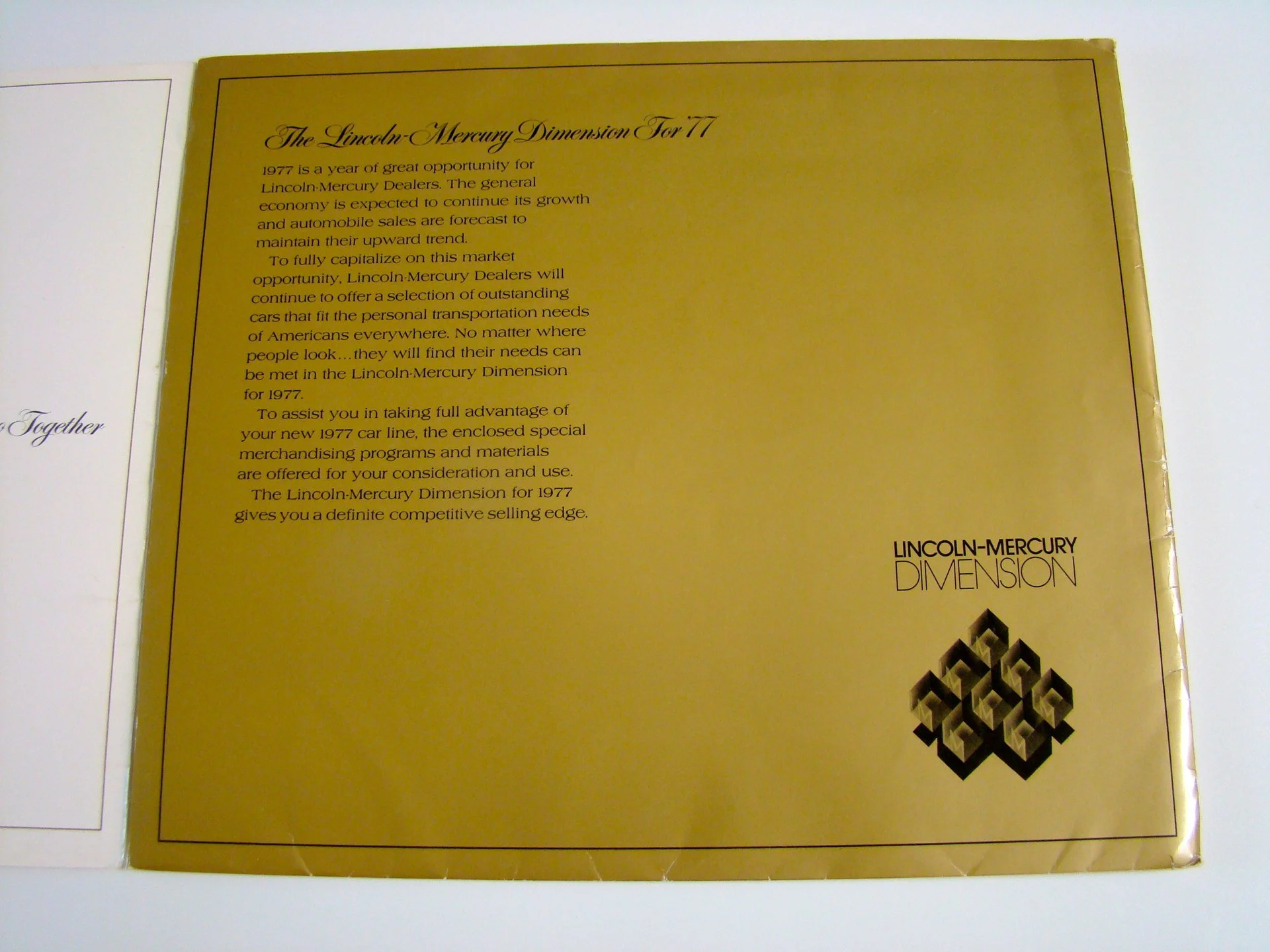 Text about the Lincoln-Mercury Dimension for 1977 with the Lincoln-Mercury logo on gold background.