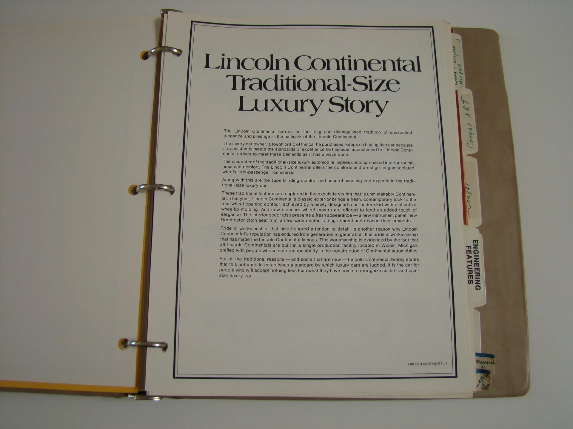 Open binder with a printed document titled 'Lincoln Continental Traditional-Size Luxury Story' on its page.
