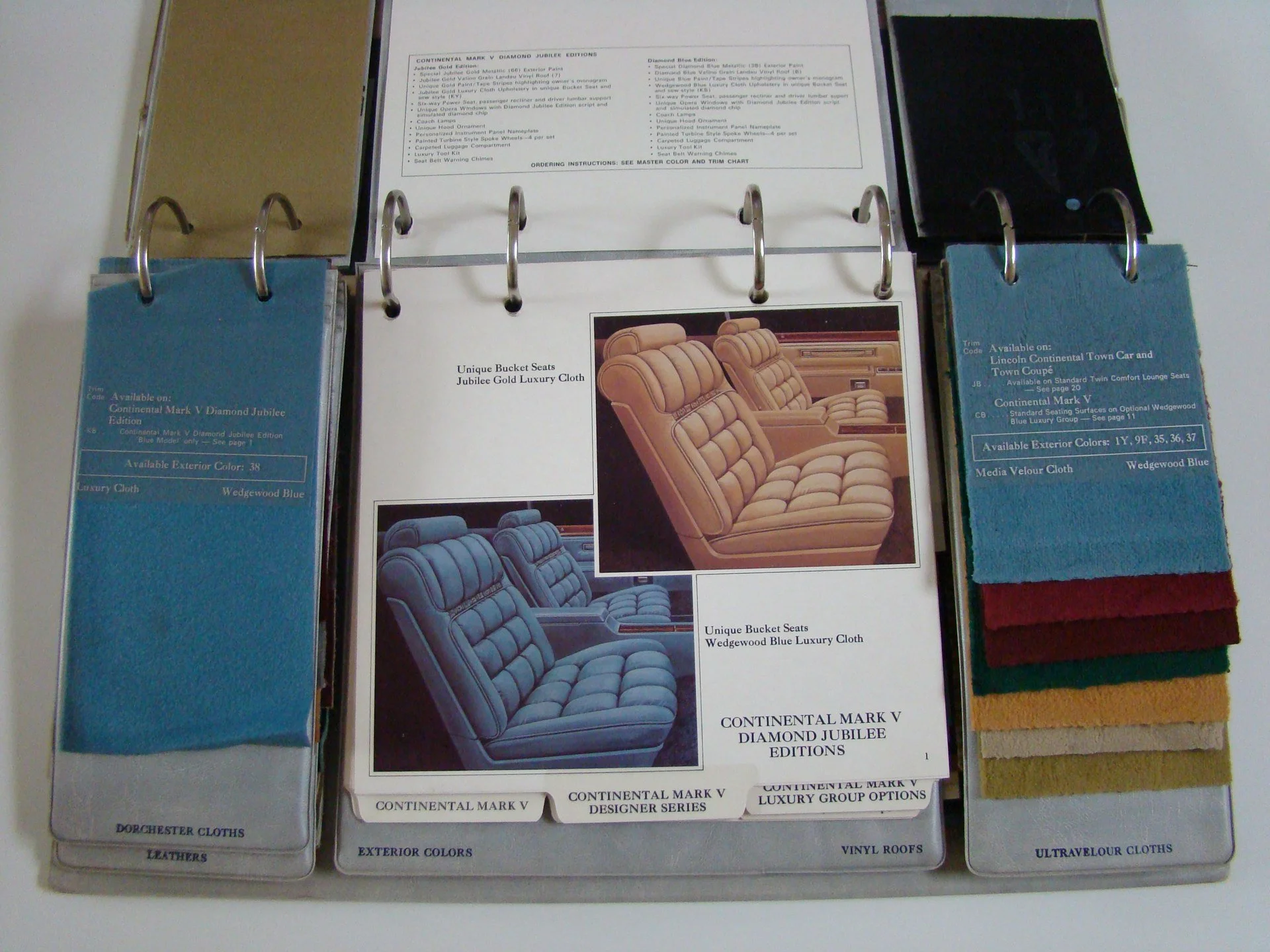 Sample book and fabric swatch catalog displaying interior car seat options, fabric color samples, and upholstery designs for luxury car seats.