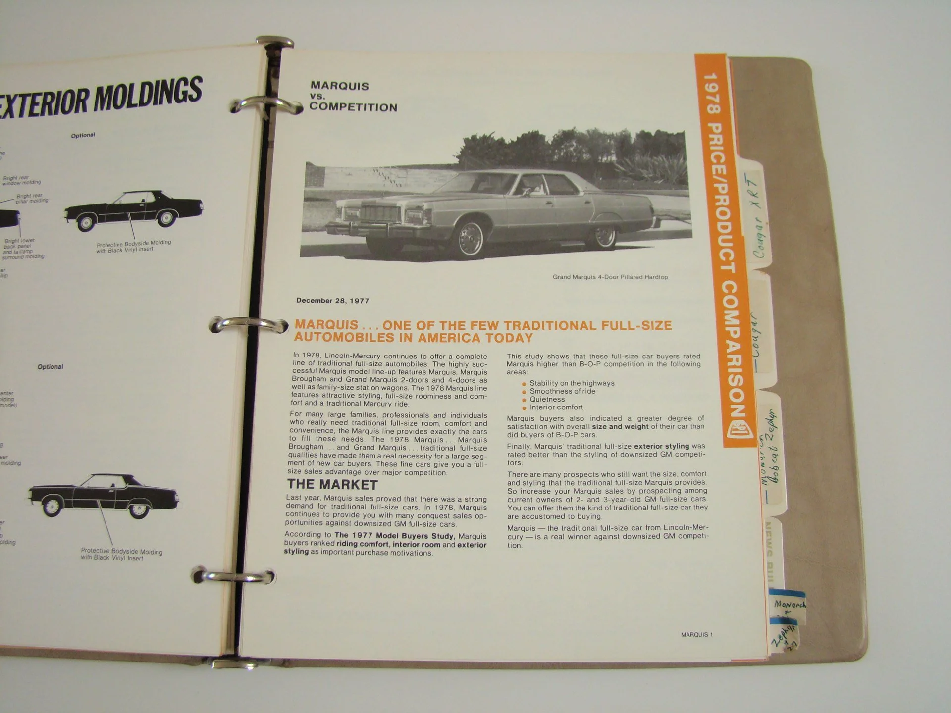 Open binder with a page displaying information and black-and-white photo of a 1977 Grand Marquis car.