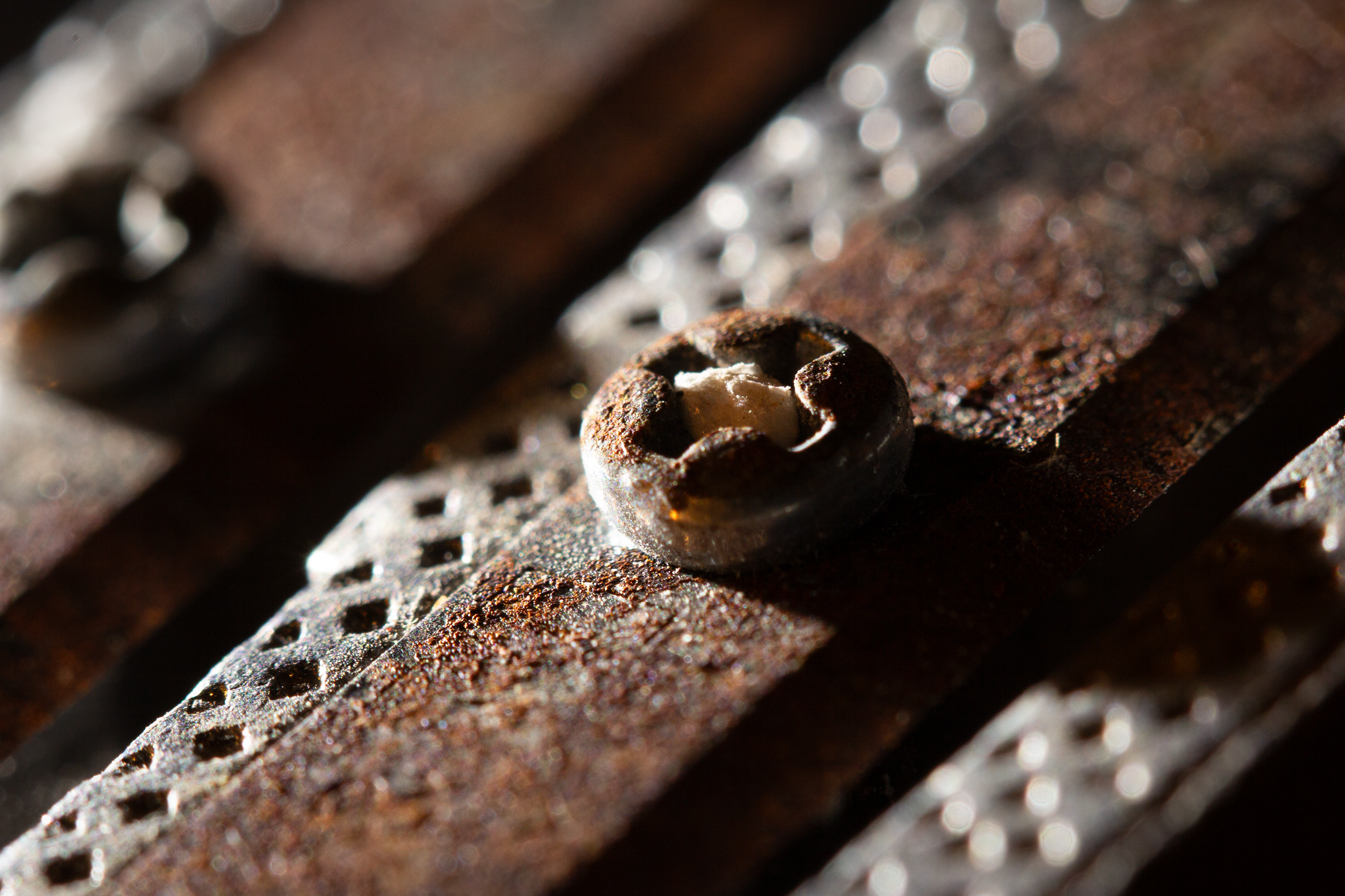 Close-up of a rusty handheld pencil sharpener with a corroded screw.