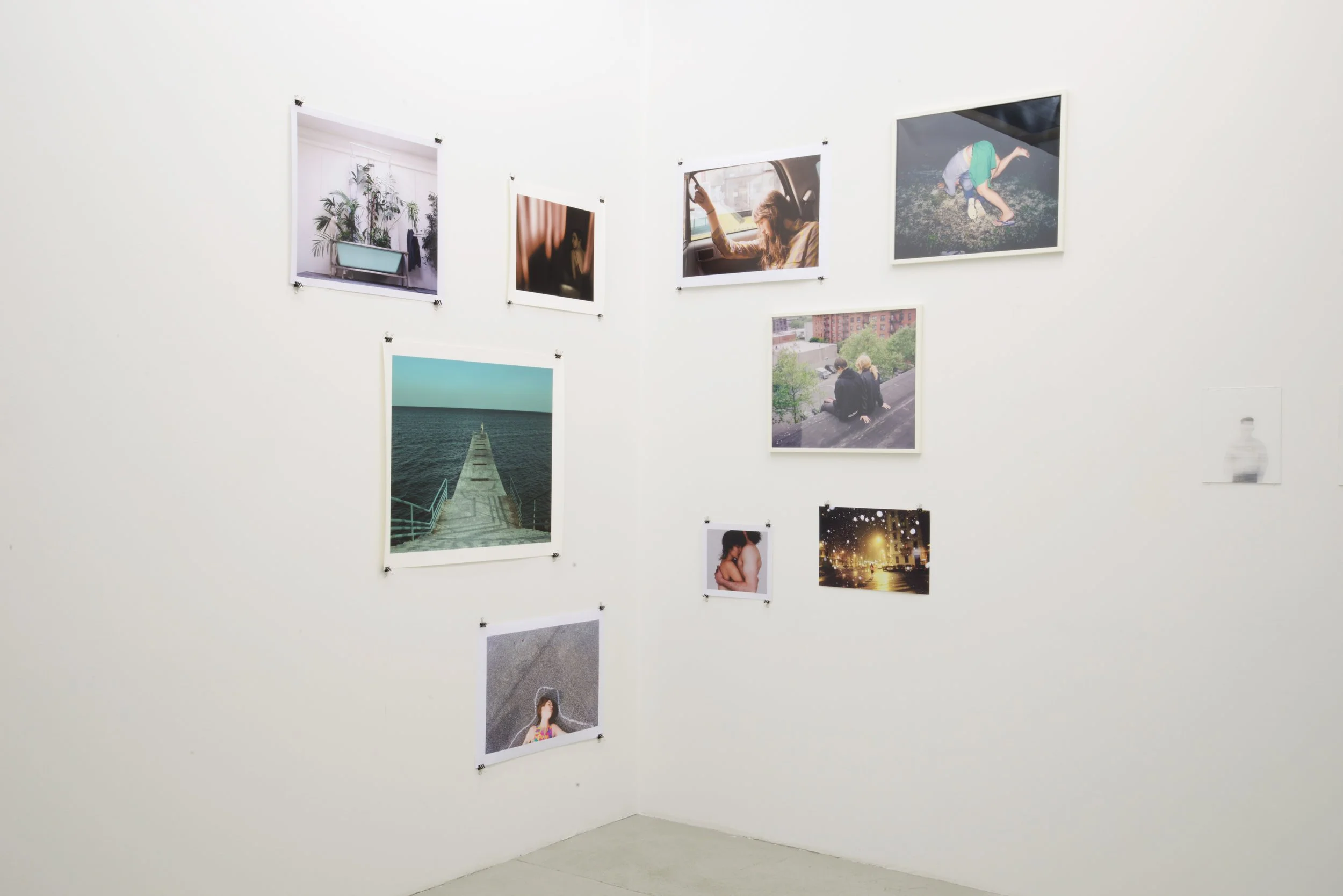 Wall with photos of various scenes including nature, people, cityscapes, and portraits, arranged in a gallery style.