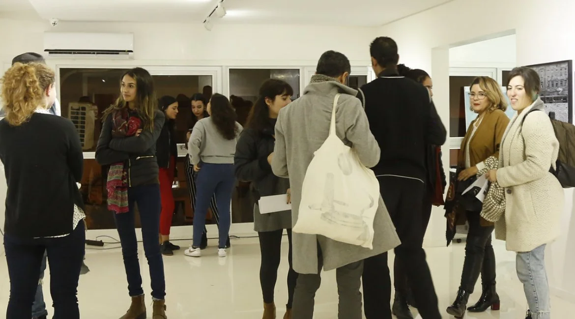 Group of people in an art gallery or exhibition, engaging and looking at artwork or displays.