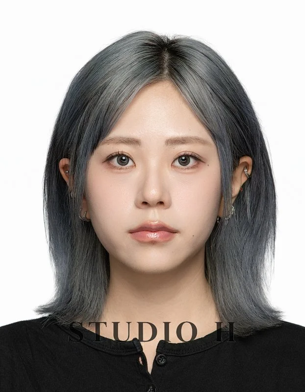 Portrait of a woman with shoulder-length gray hair, wearing a black top, looking directly at the camera.