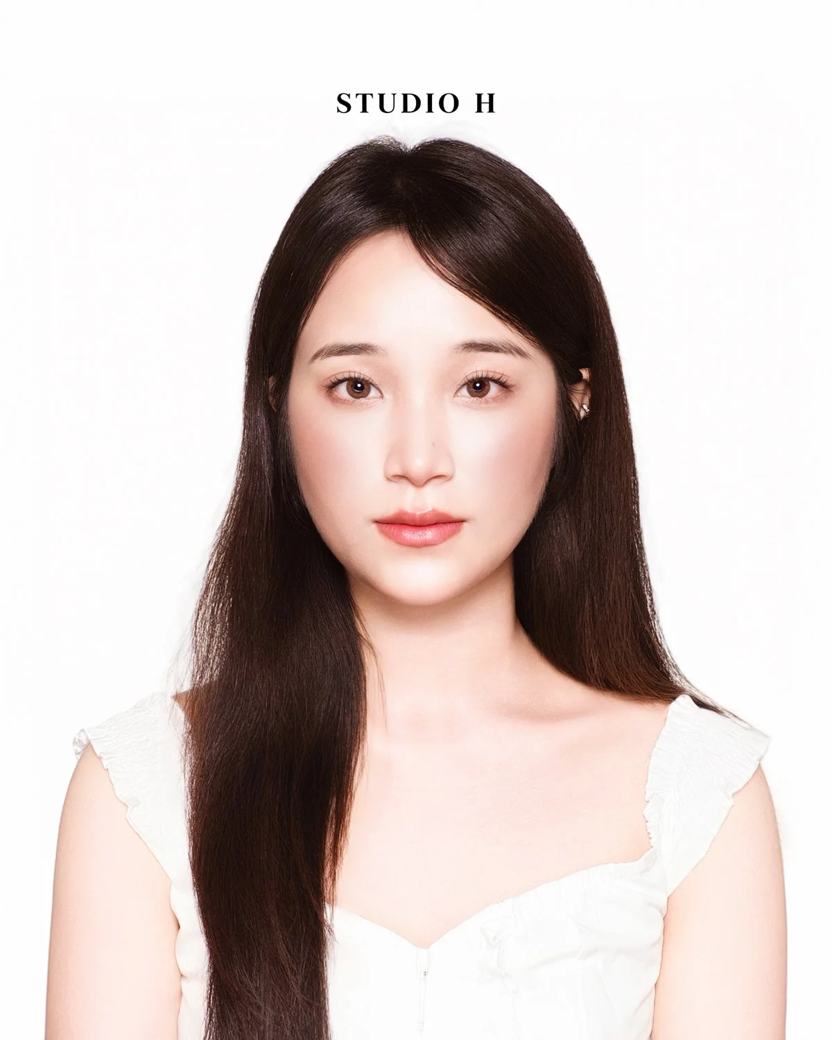 A woman with long dark hair and a light skin tone looking directly at the camera against a plain white background. The text 'STUDIO H' appears above her head.