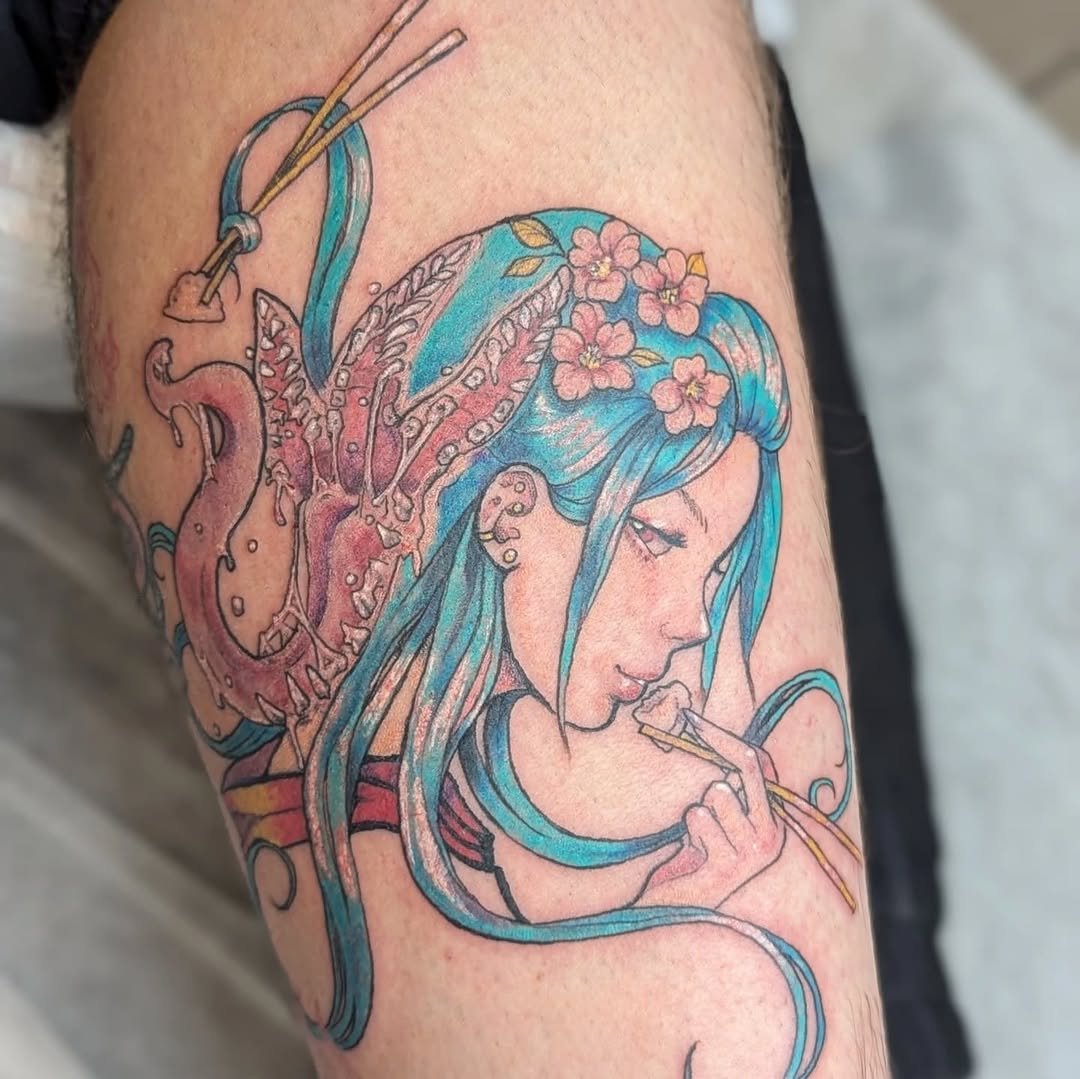 Colorful tattoo of a woman with long blue hair adorned with pink flowers, holding chopsticks and eating.
