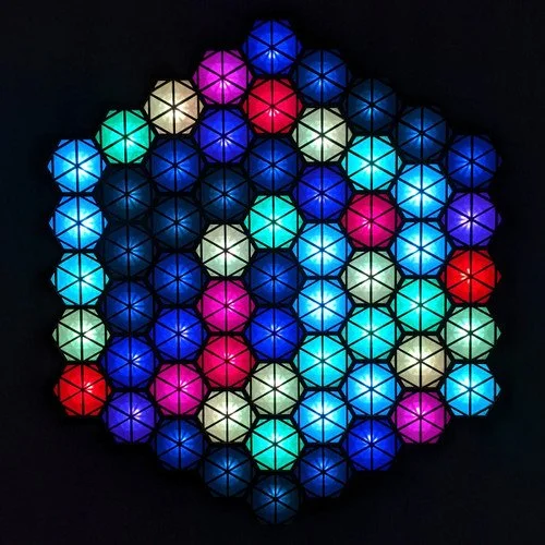 Colorful illuminated geometric lights arranged in a circular pattern.