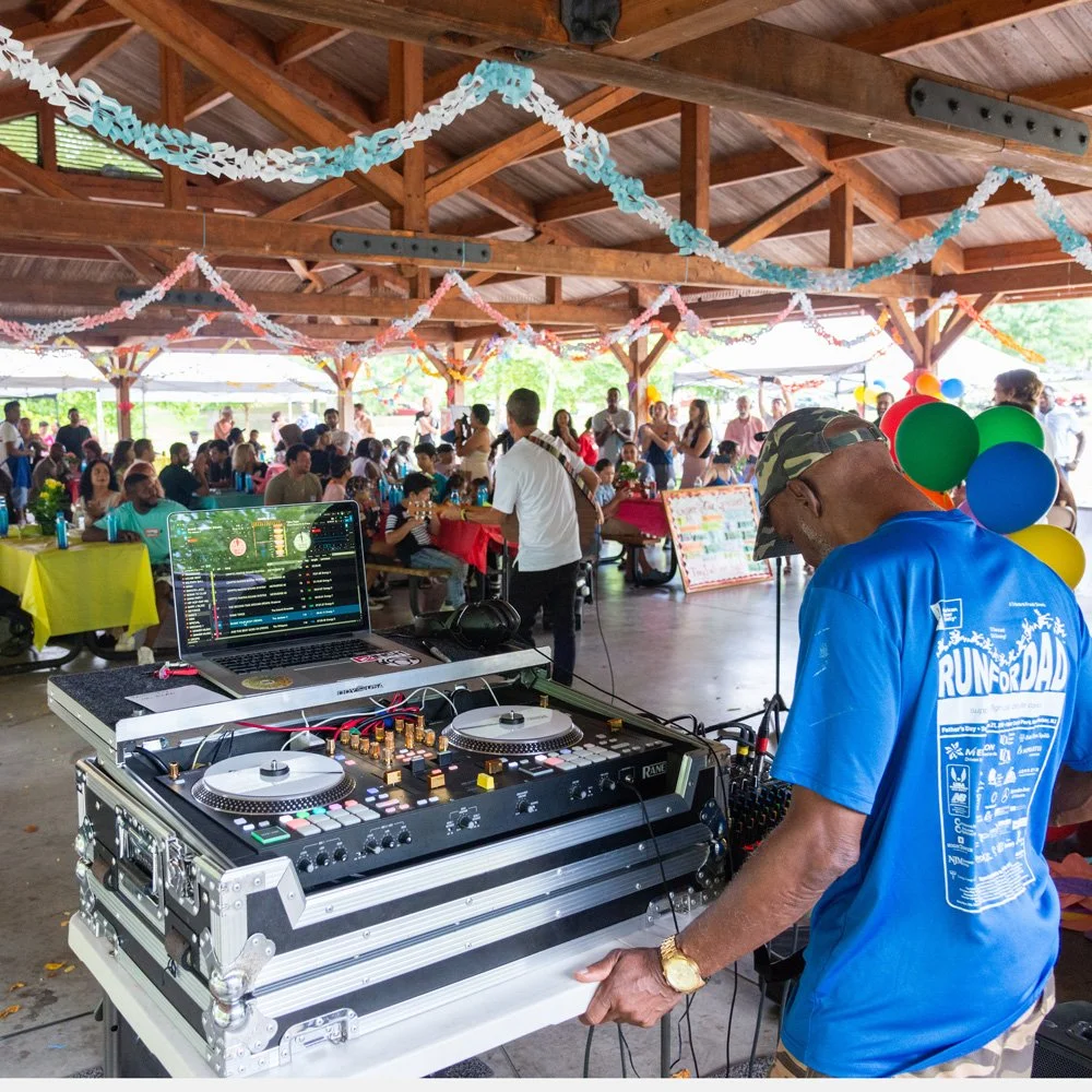 A photo of a DJ and a large crowd at a festively decorated pavilion for ESWA's Anniversary Celebration.