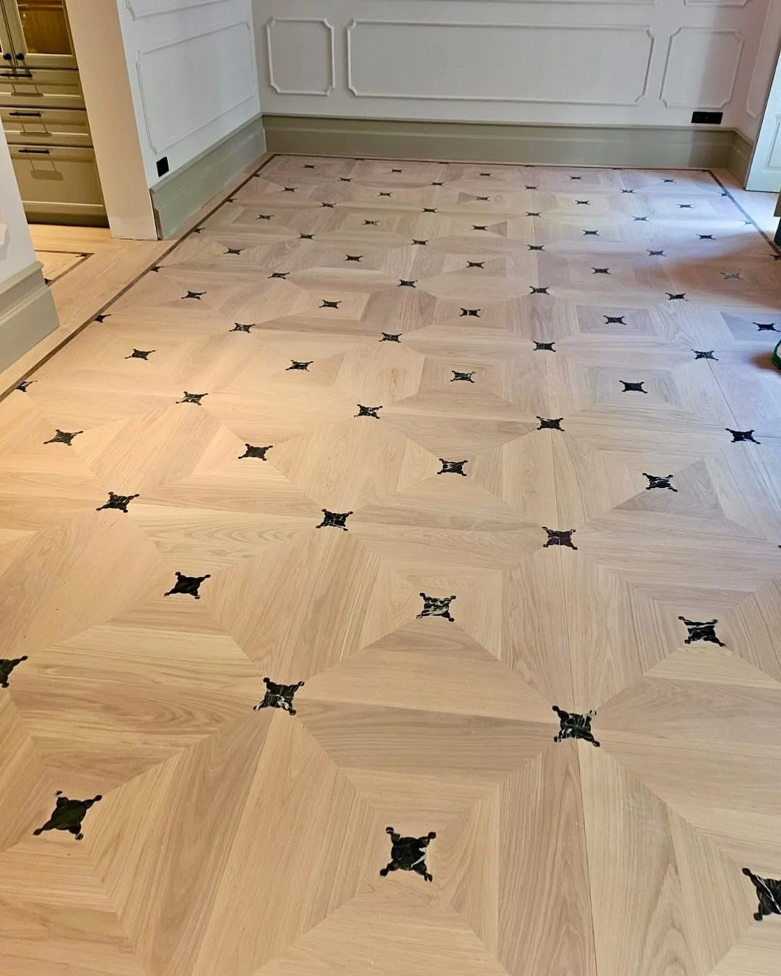 Nuestra loseta Agra de roble con incrustaciones de m&aacute;rmol en dos versiones, mini para el hall y grande para el sal&oacute;n rematada con un junquillo de wenge.