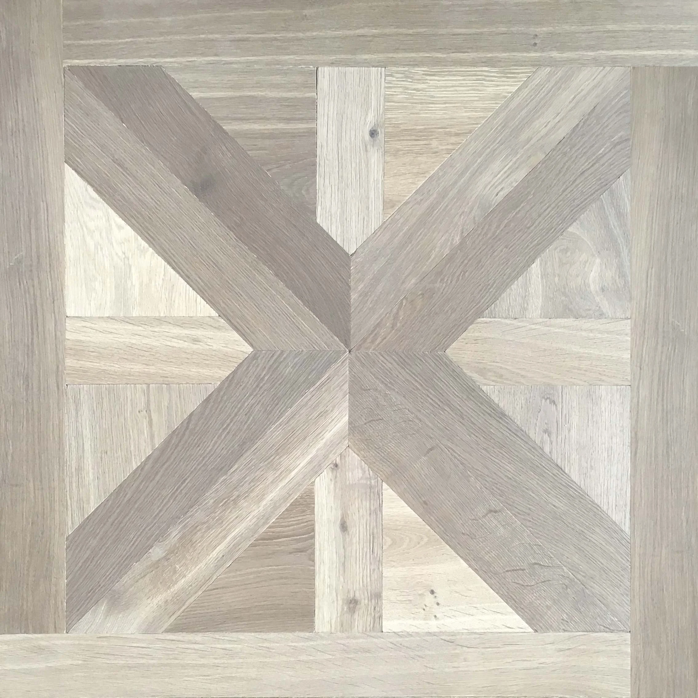 Suelo de madera en patrón geométrico con varias tonalidades de beige y gris.