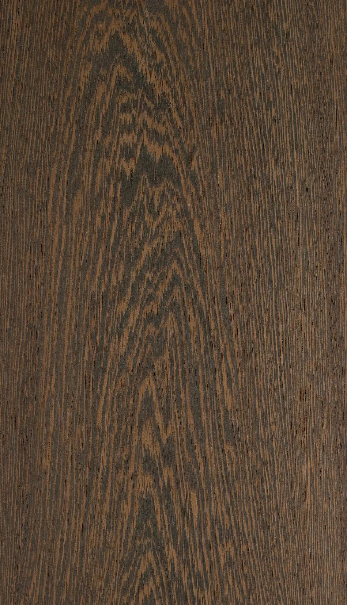 Superficie de madera de color marrón oscuro con vetas y patrones naturales.