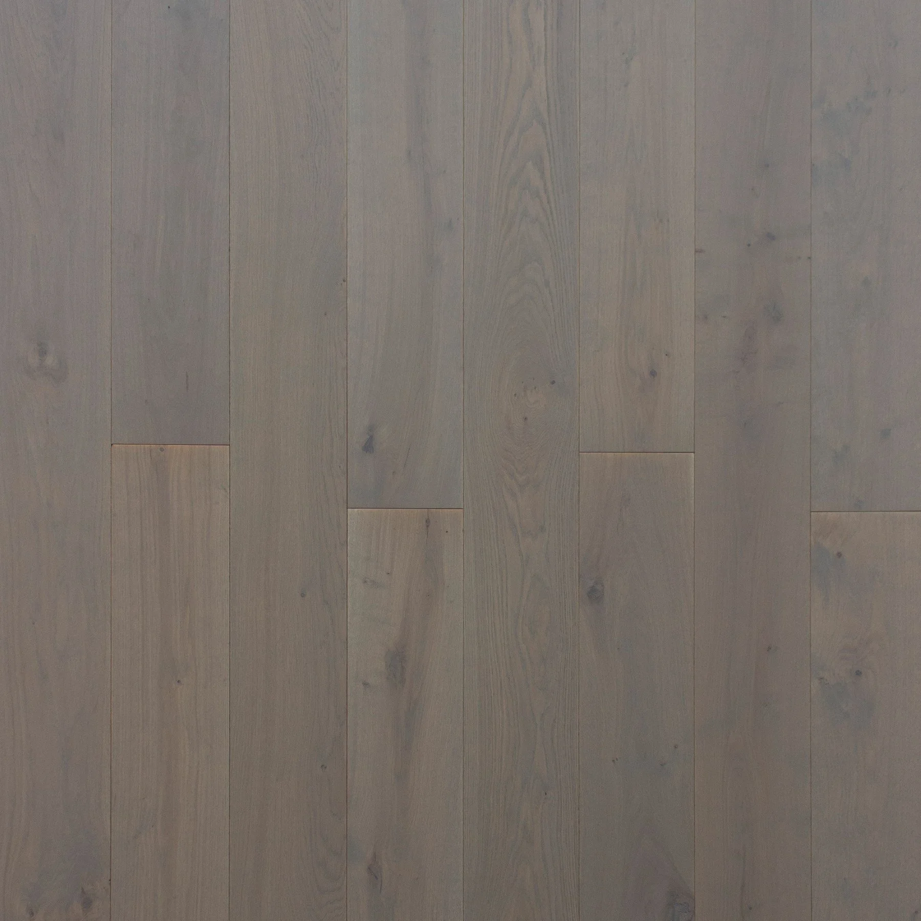 Superficie de suelo de madera clara, con tablas largas y delgadas, con vetas visibles y nudos menores