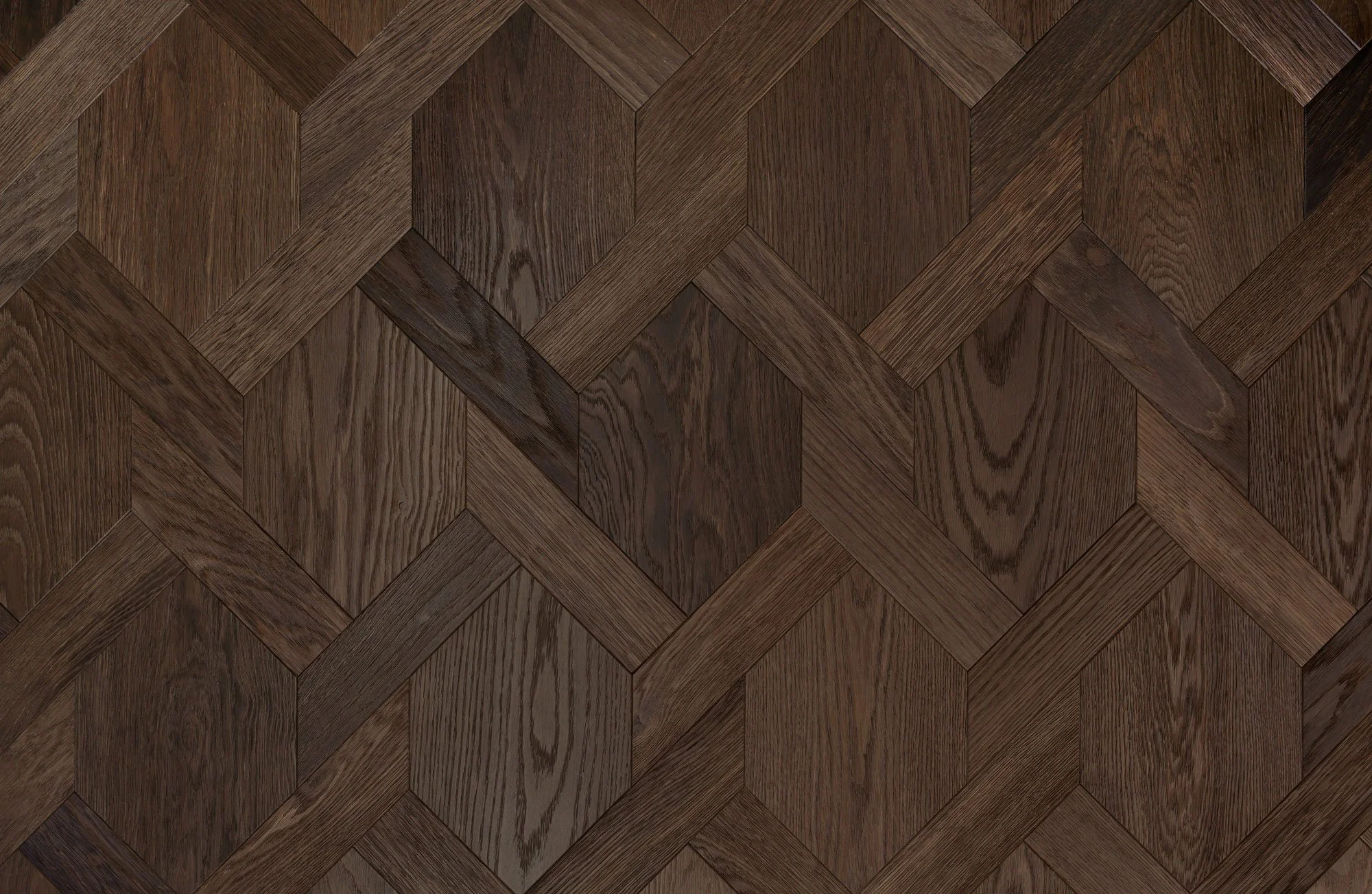 Superficie de piso de madera con patrón en forma de hexágonos y líneas entrelazadas en tonos marrón.