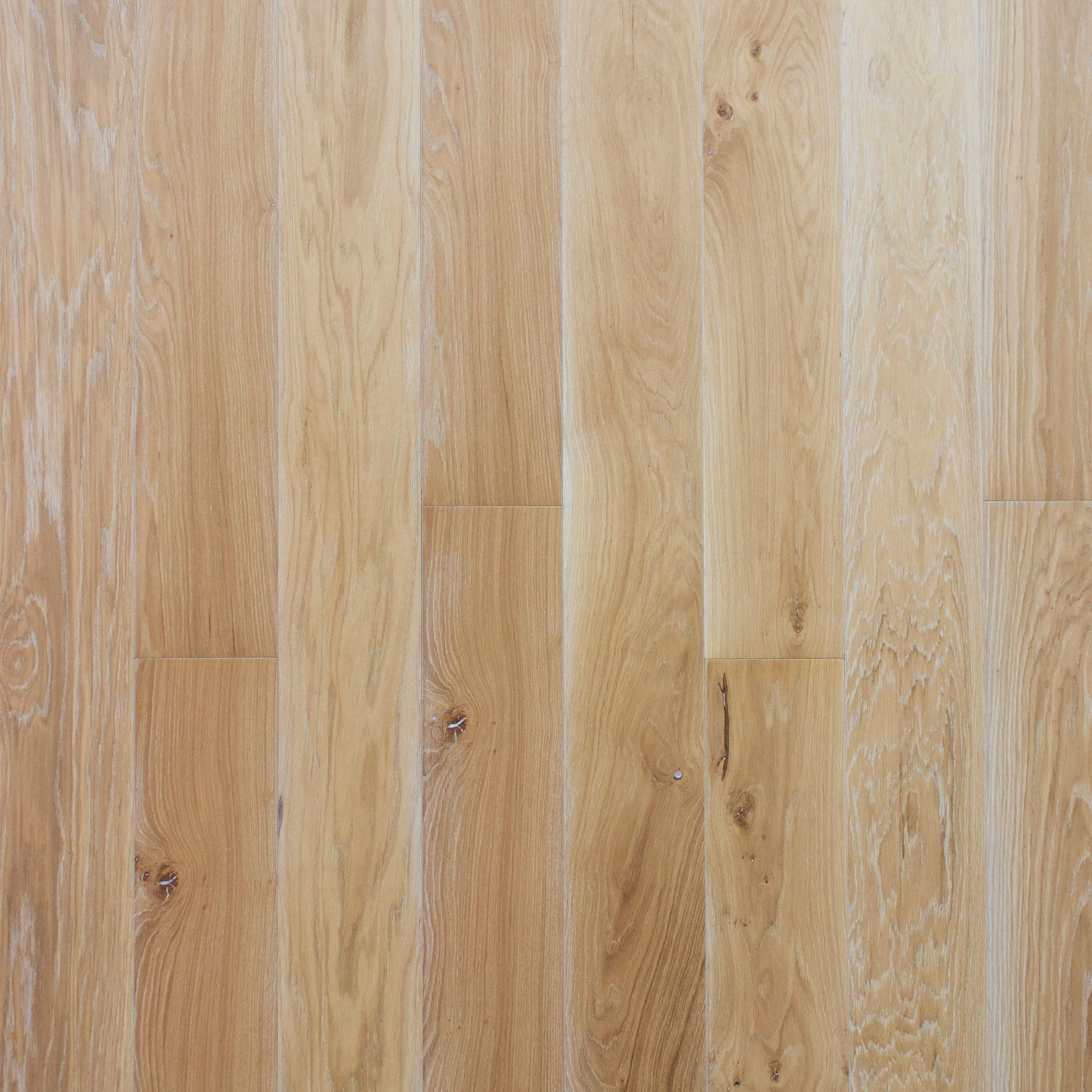 Superficie de piso de madera clara con vetas naturales y nudos.