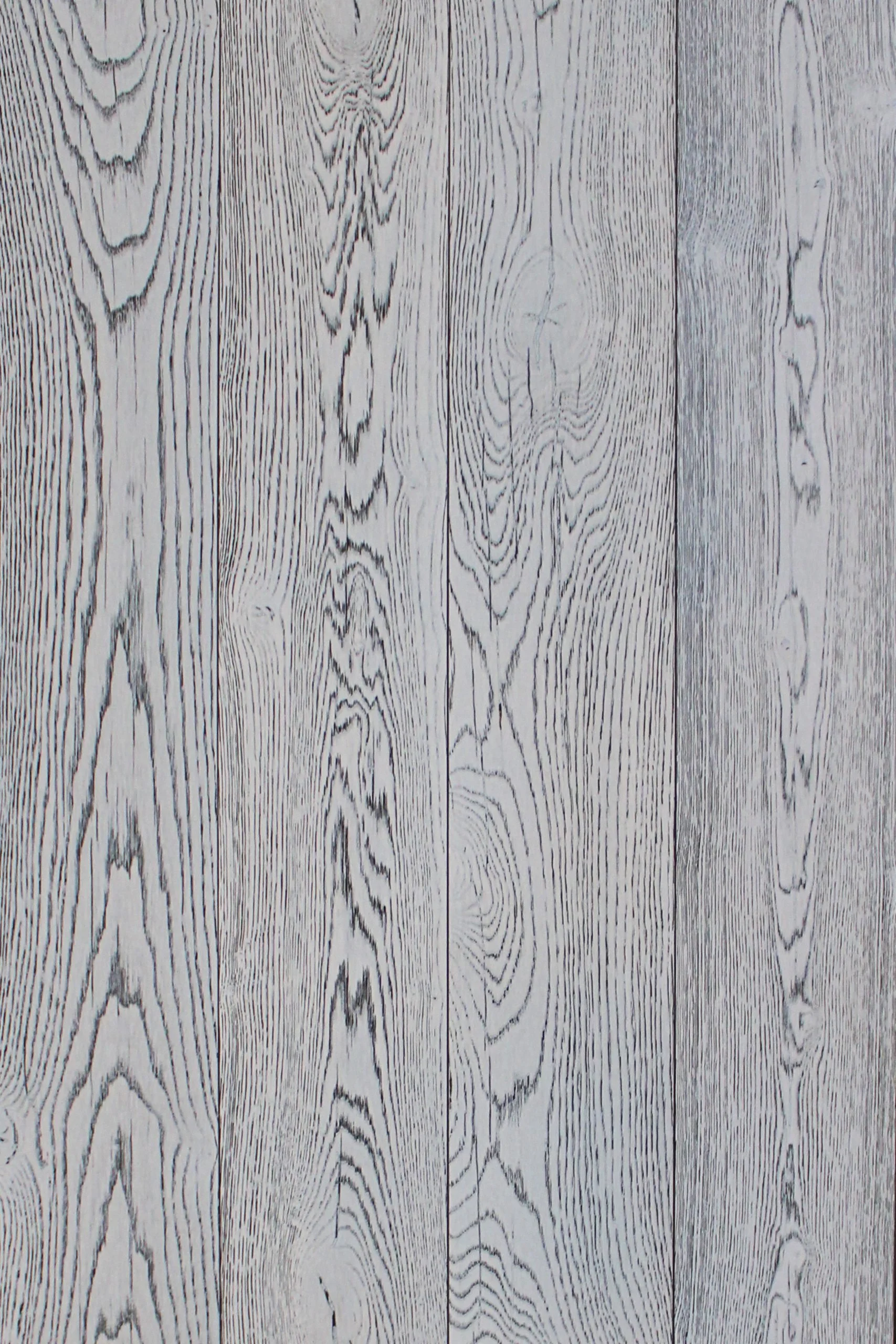 Pared de madera pintada en color gris claro con vetas y nudos negros que simulan la apariencia natural de la madera.