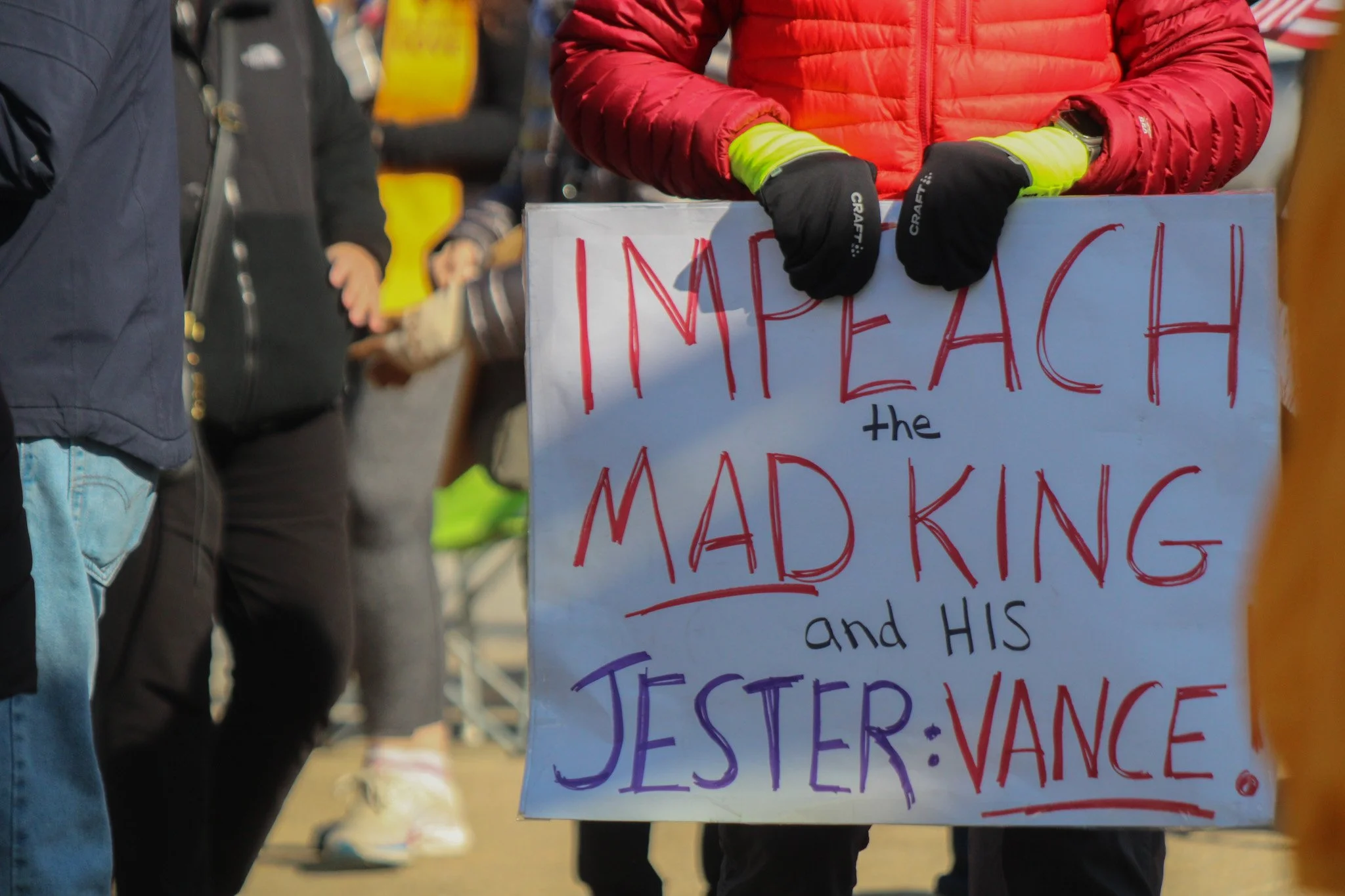 A protest sign saying "Impeach the mad king and his jester Vance"
