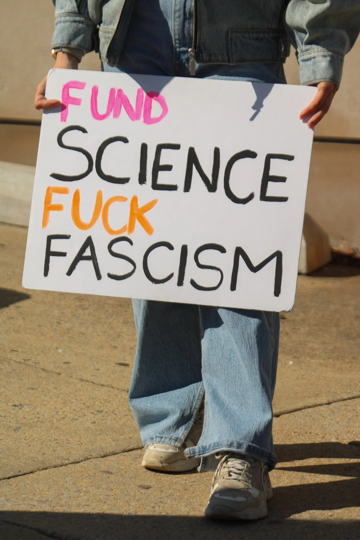 A sign that says "Fund science, fuck fascism"
