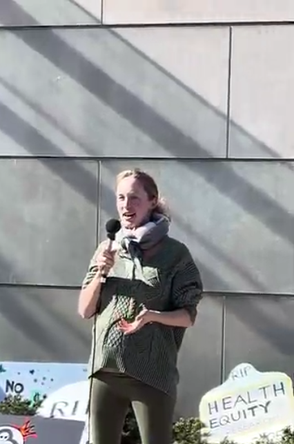 A pregnant woman speaks into the microphone at an NIH Vigil