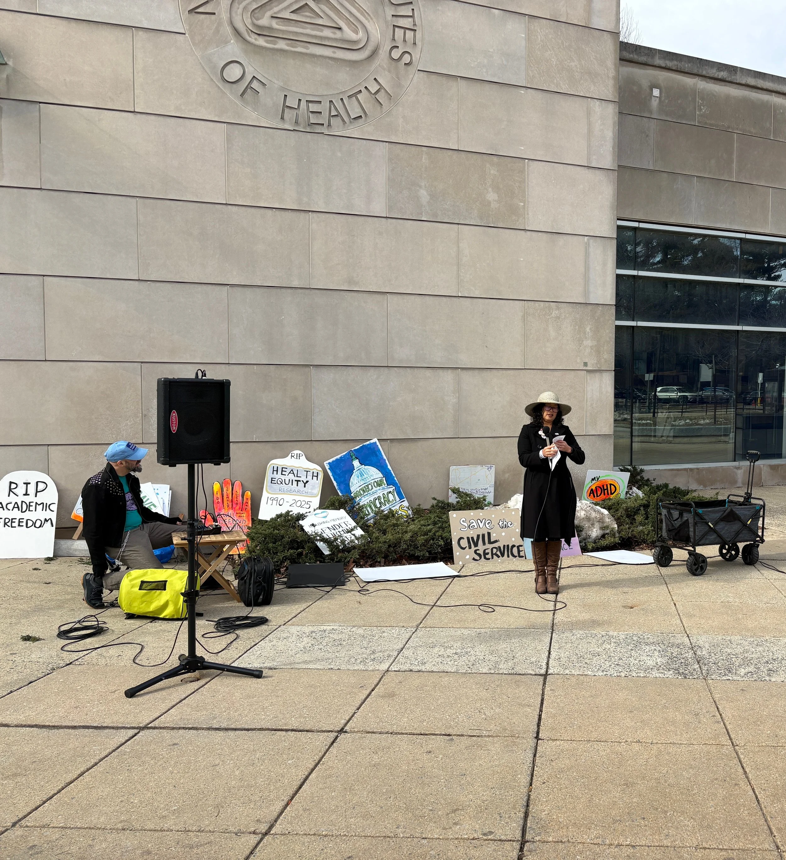 A person speaks at an NIH vigil