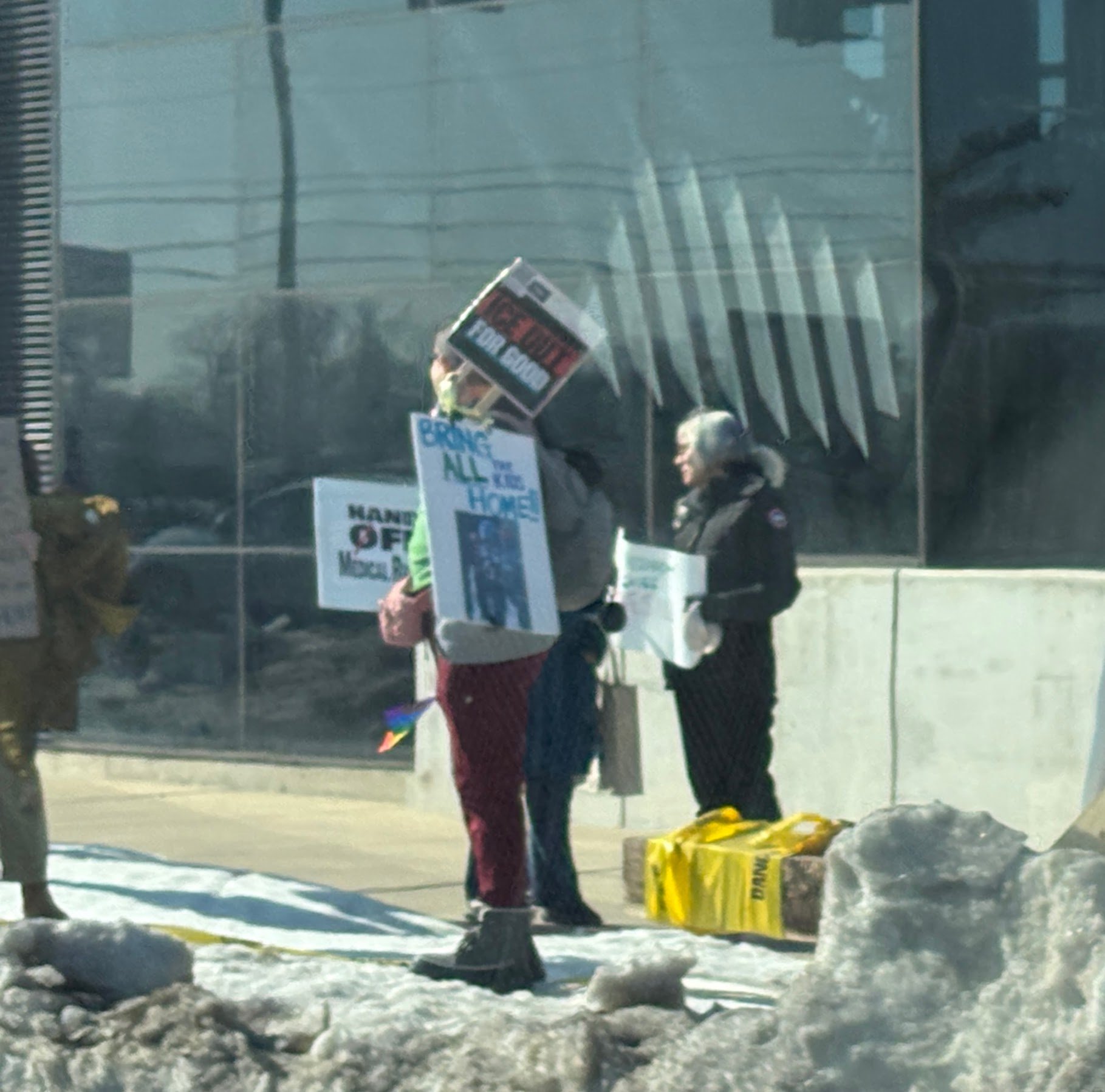 people holding protest signs at an NIH vigil