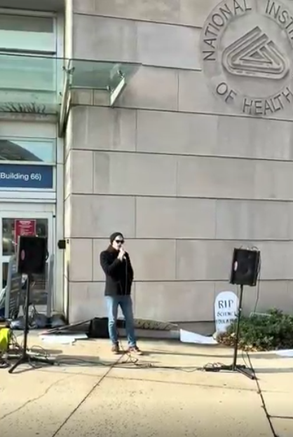 A man speaks at an NIH vigil