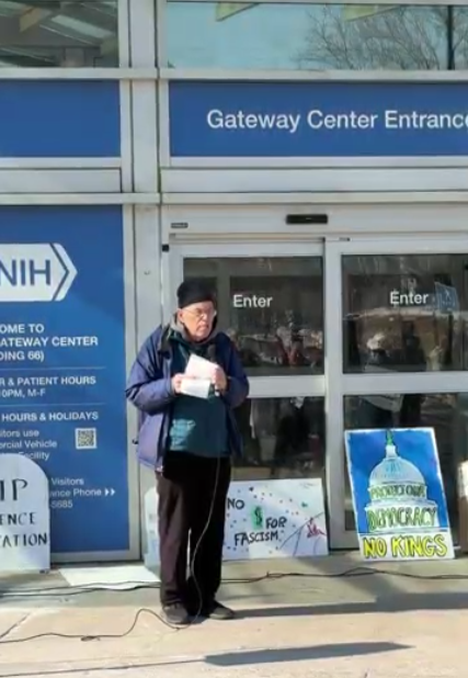 A person speaking at an NIH vigil