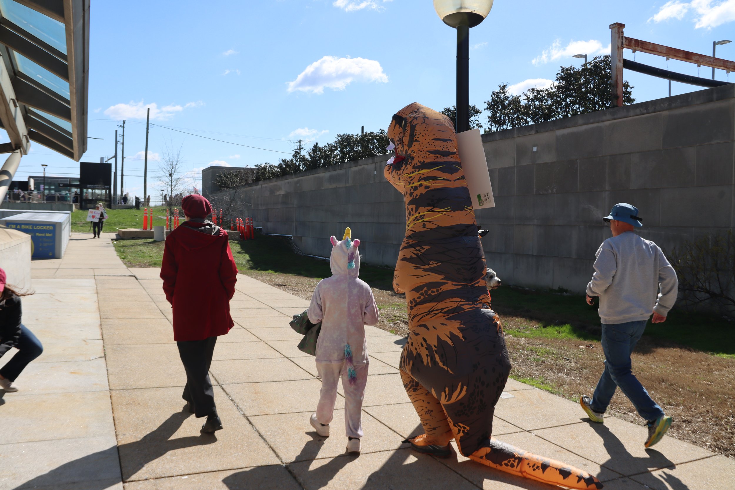 A unicorn and a dinosaur walking away after the rally