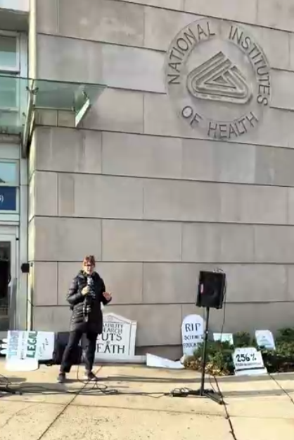 A woman speaks at an NIH vigil