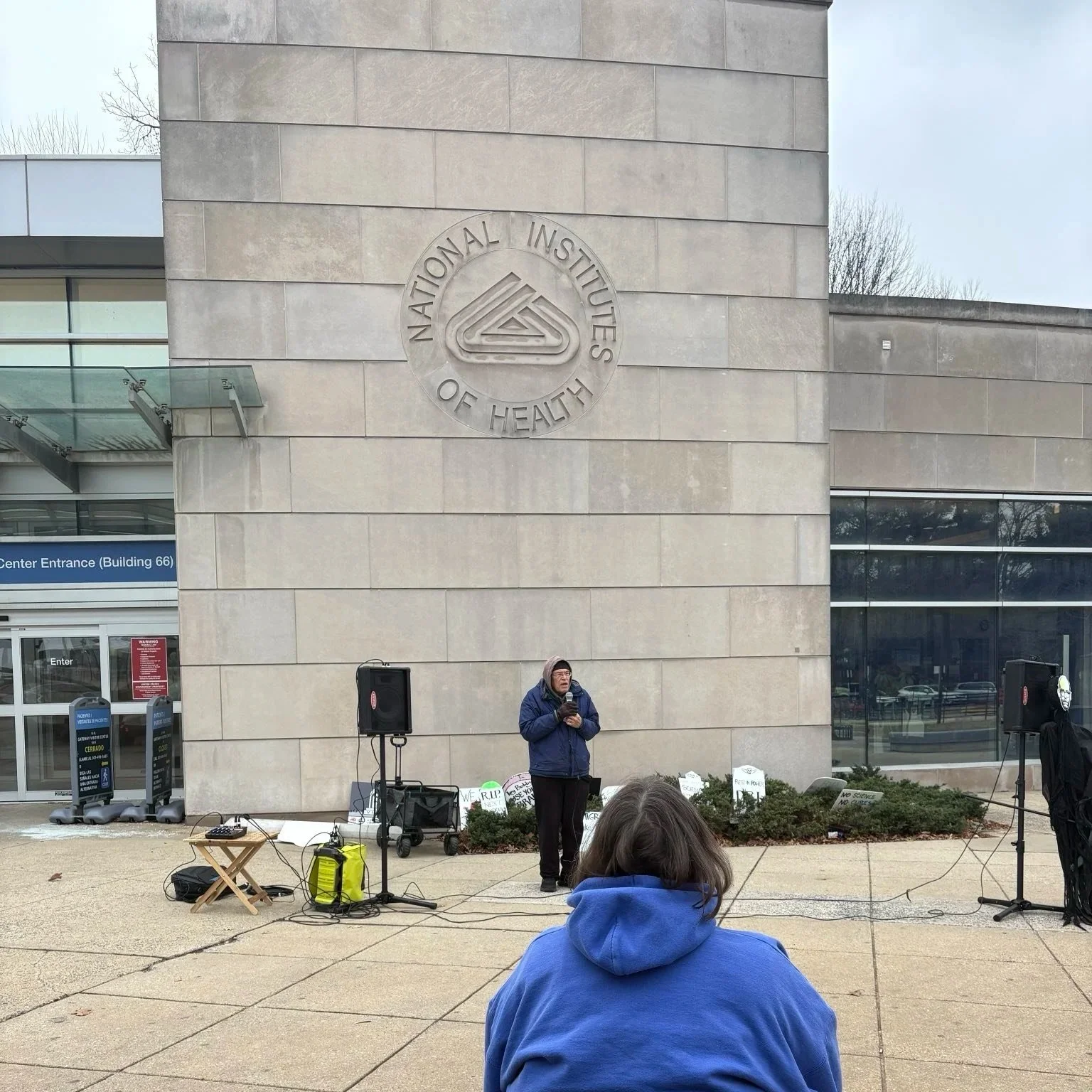 A person speaks at an NIH vigil