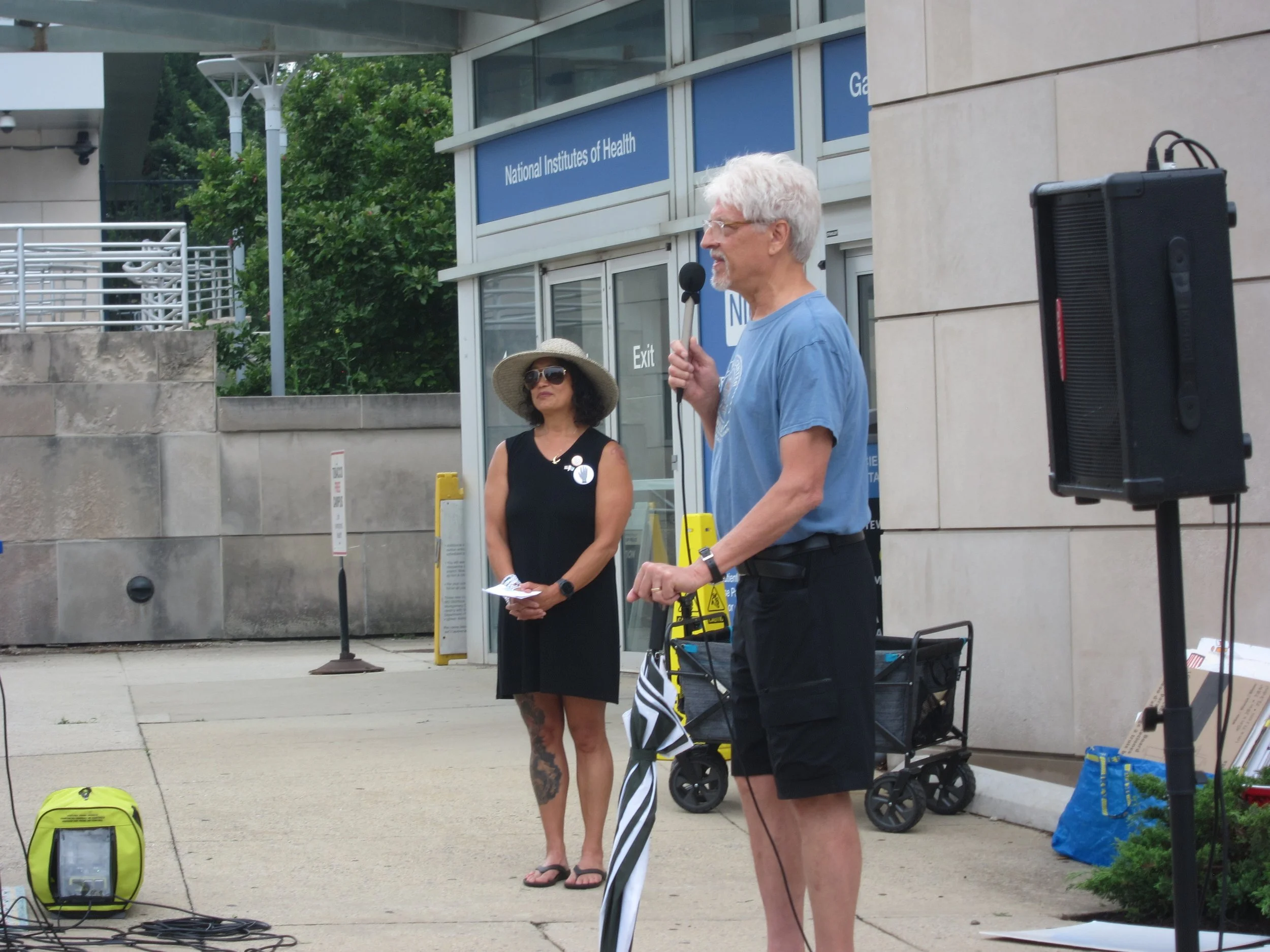 A man speaks into the microphone while the emcee looks on