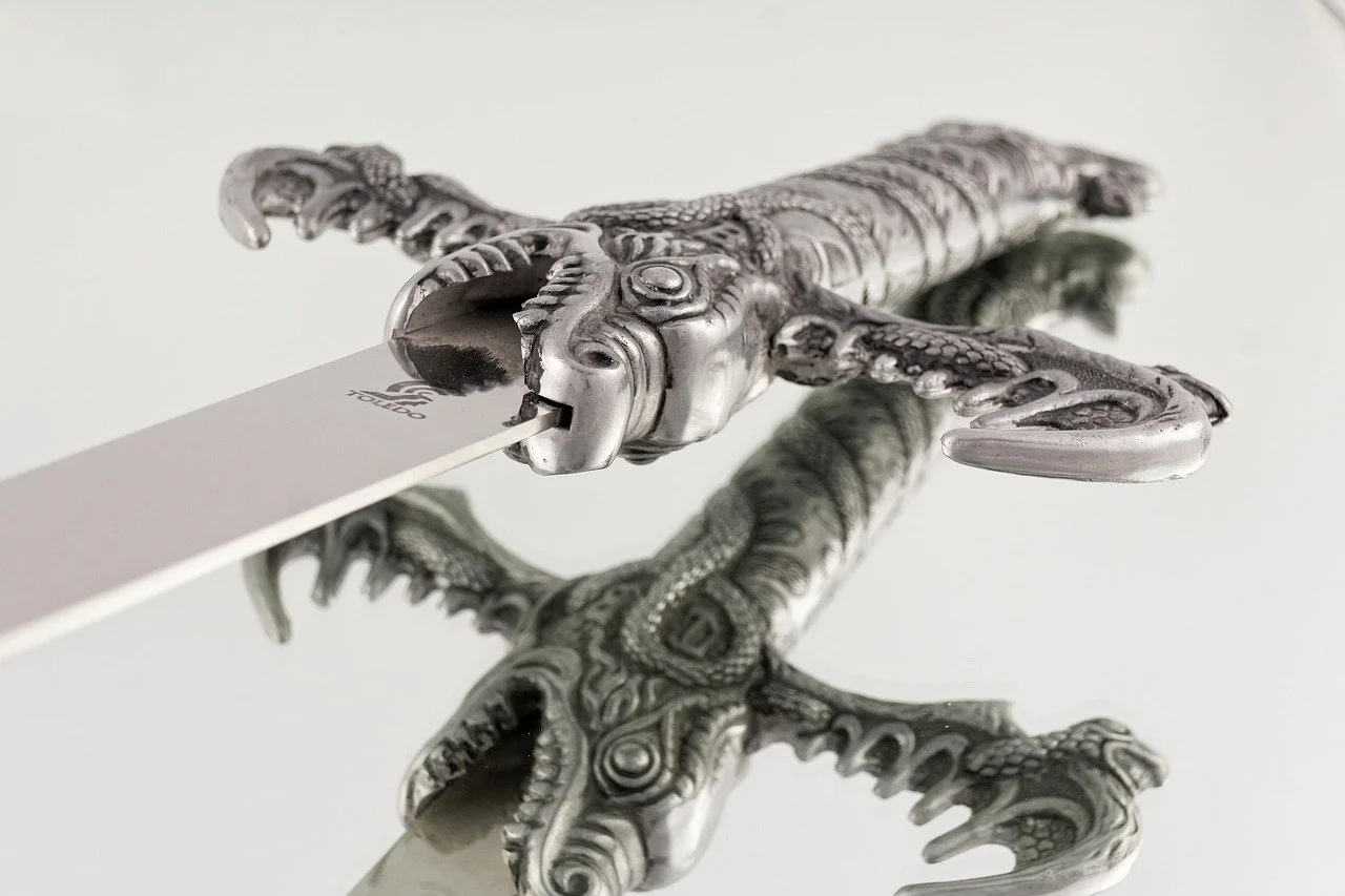 A sword with a silver dragon-like creature on the hilt.