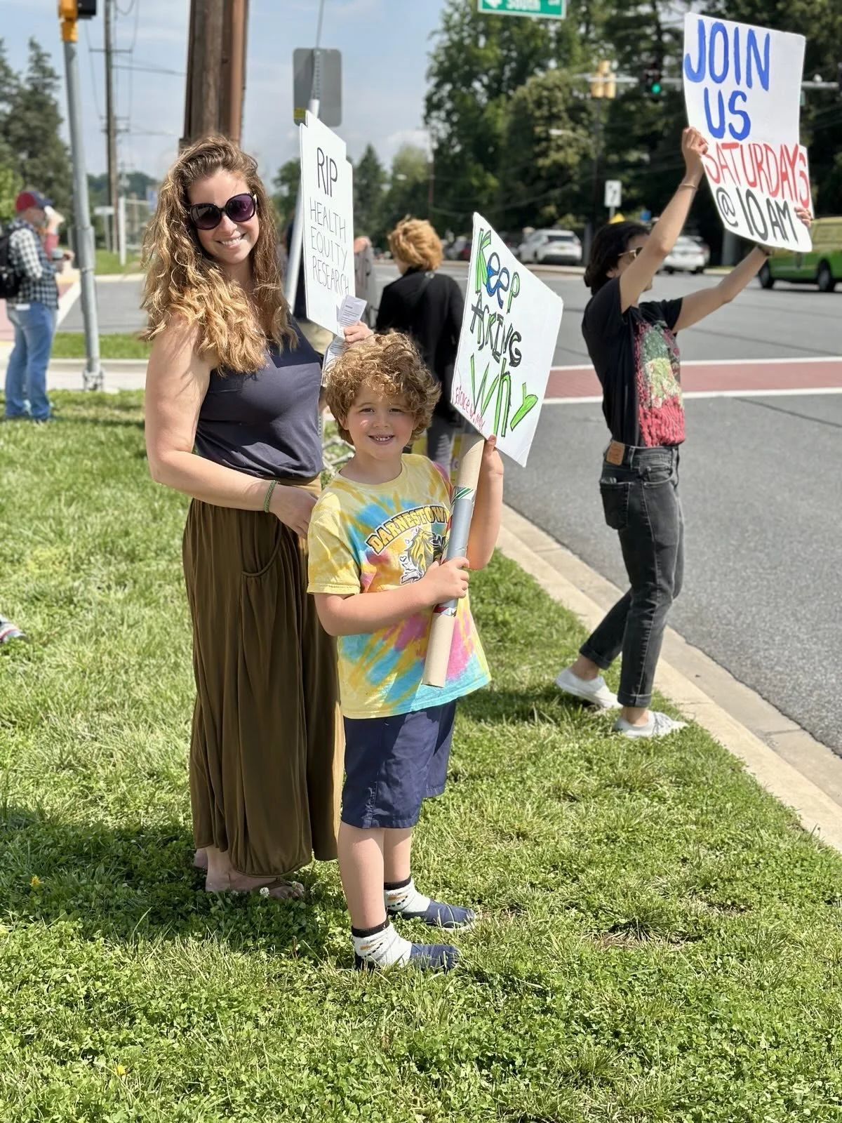Protestors hold signs by the roadside