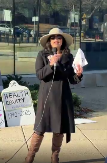 A woman speaks at an NIH vigil