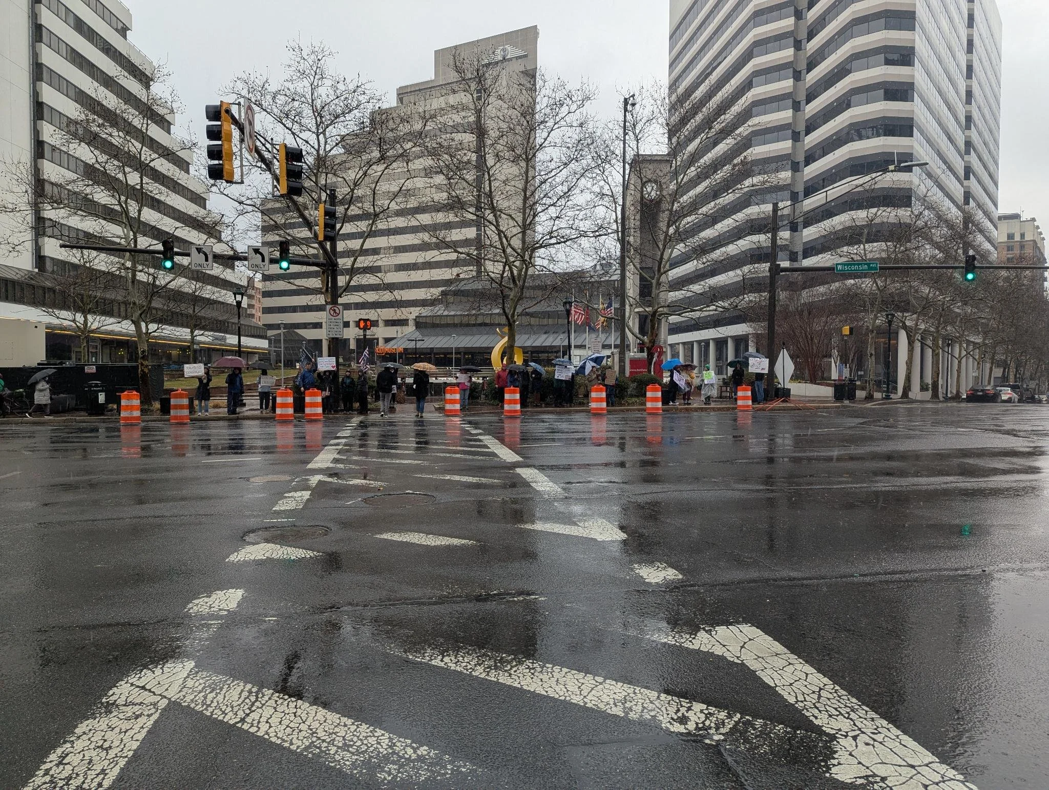 A group of protestors in the rain at the Bethesda Metro station