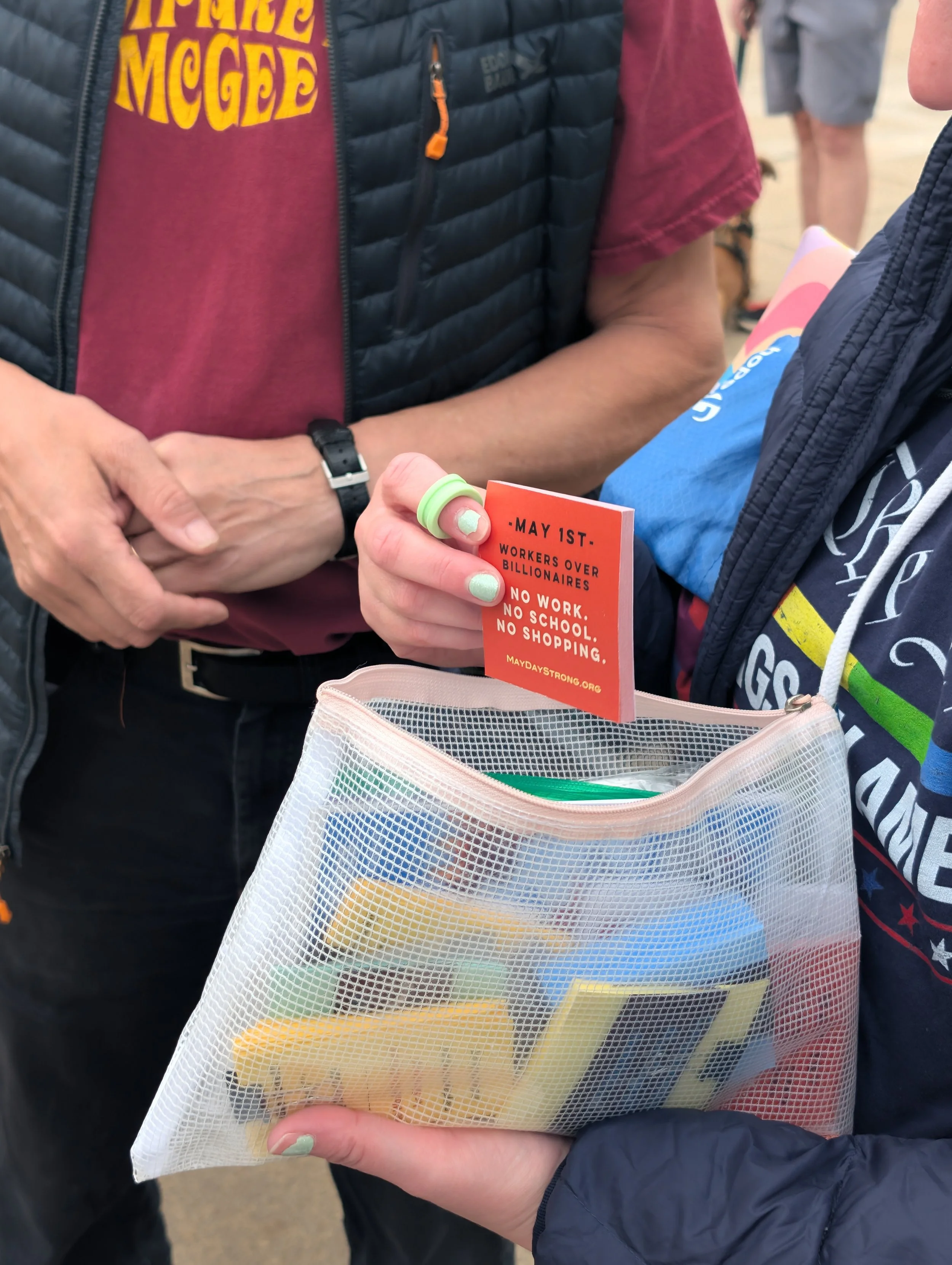 A person holding a bag of May Day protest materials