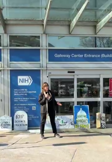 A person speaking at an NIH vigil