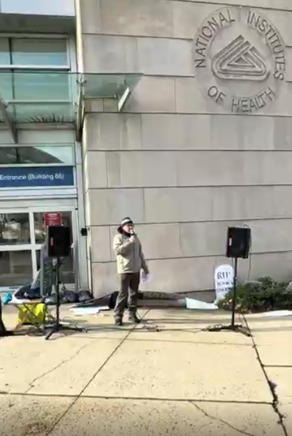 A man speaks at an NIH vigil