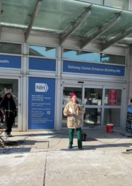 A person speaks at an NIH vigil