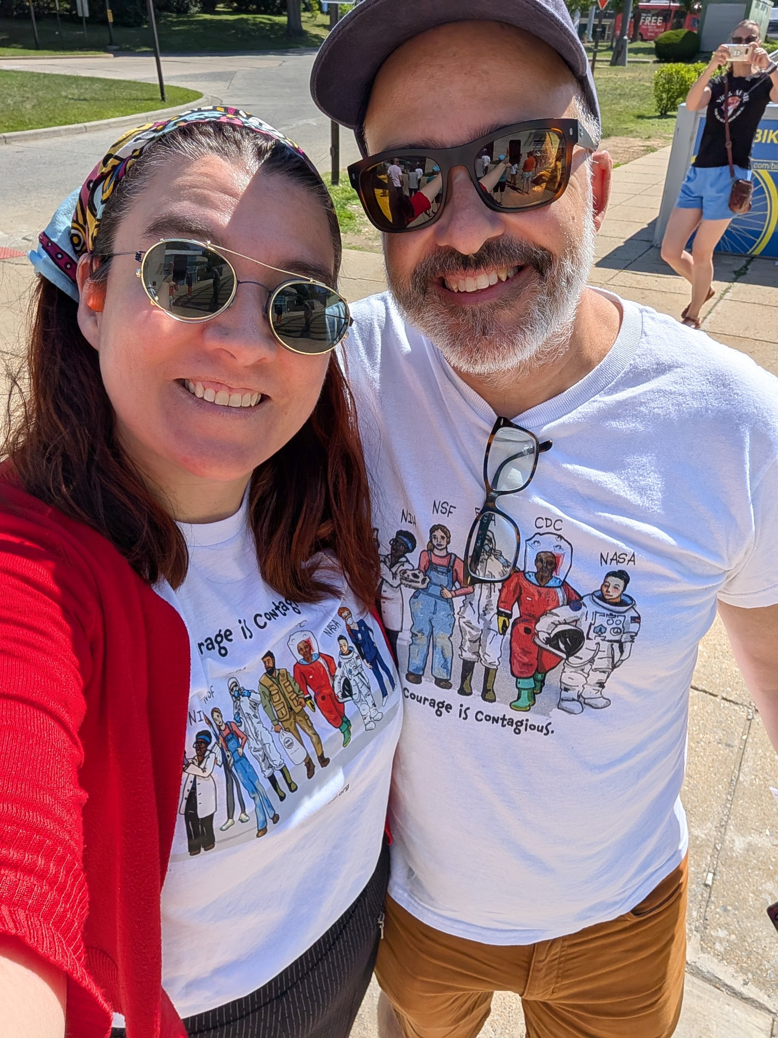 Two NIH Vigil attendees smile in matching “Courage is Contagious” shirts.