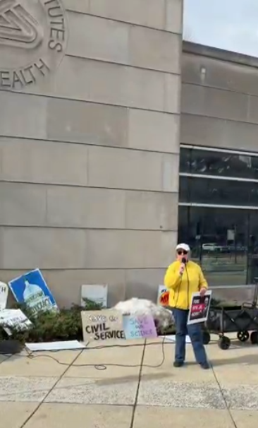 A person speaks at an NIH vigil