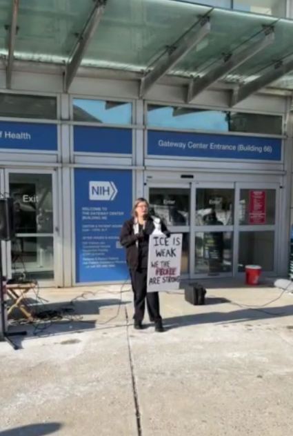A person speaks at an NIH vigil