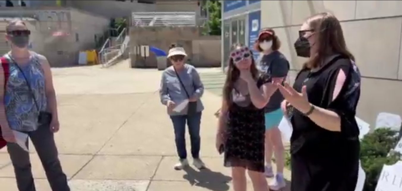 People listen to a speaker at an NIH Vigil