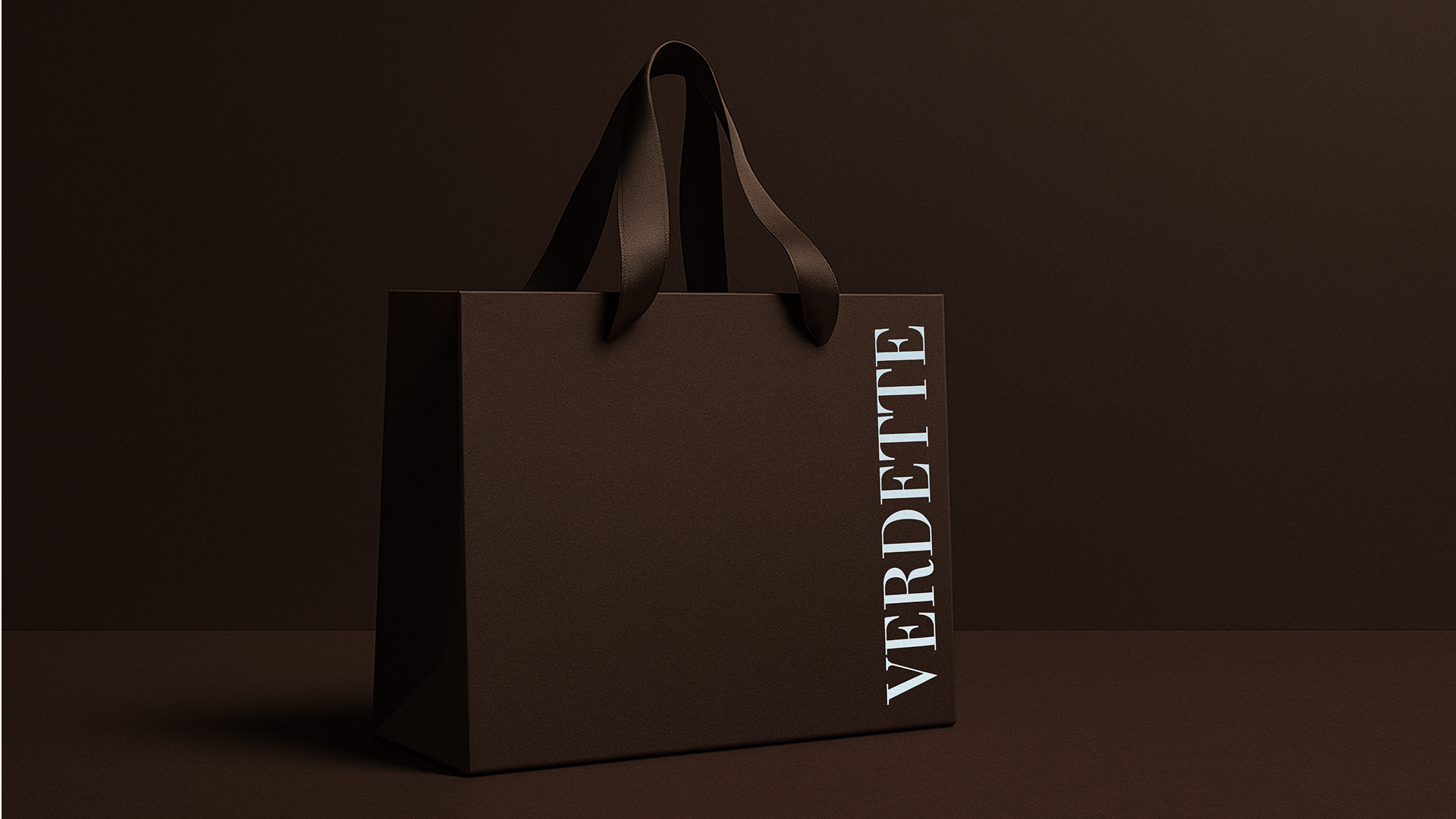 Dark brown shopping bag with black handles, against a matching brown background.