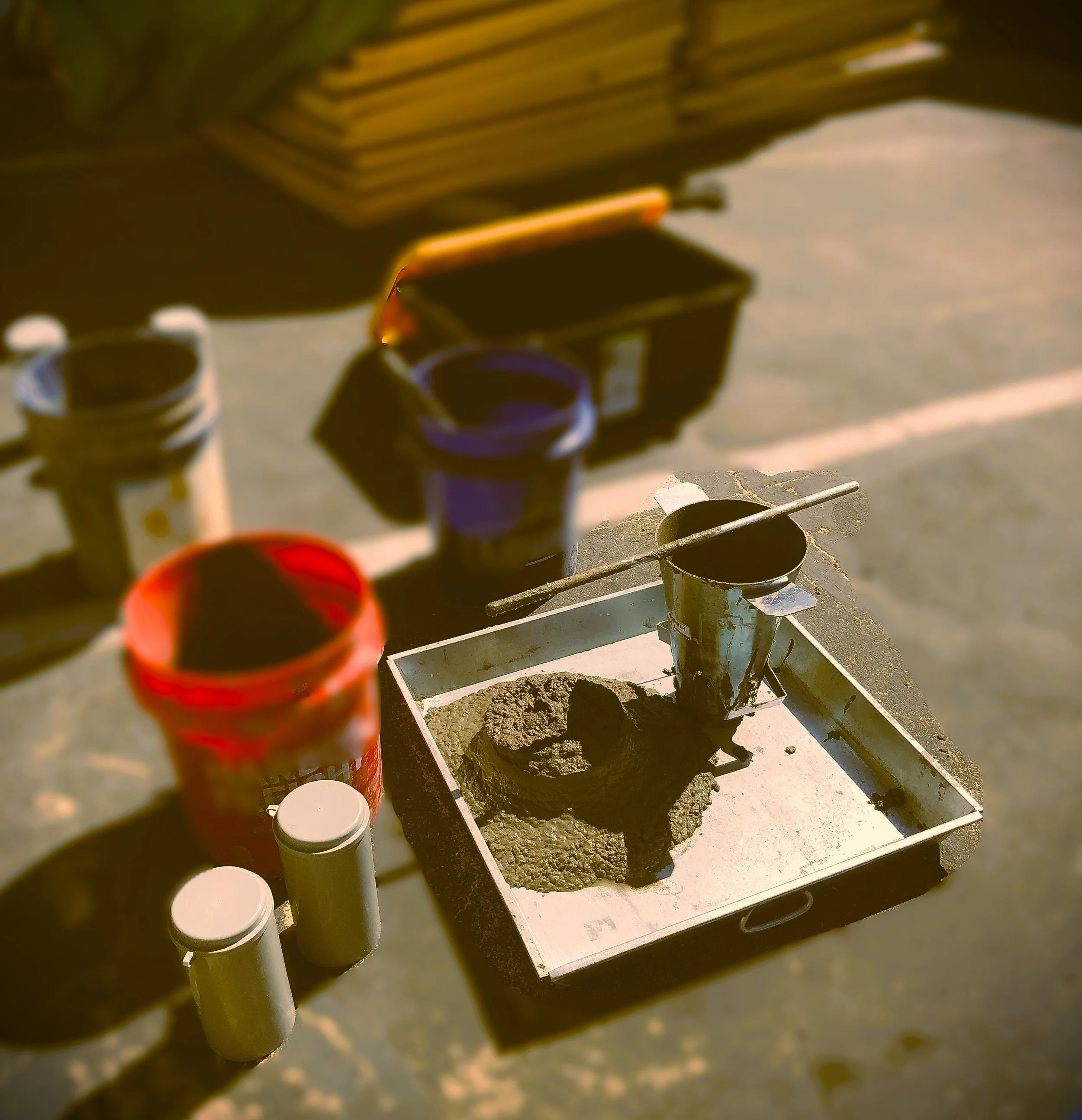 Illustration of an industrial factory with a magnifying glass and a check mark, and the words "Quality Control" underneath.