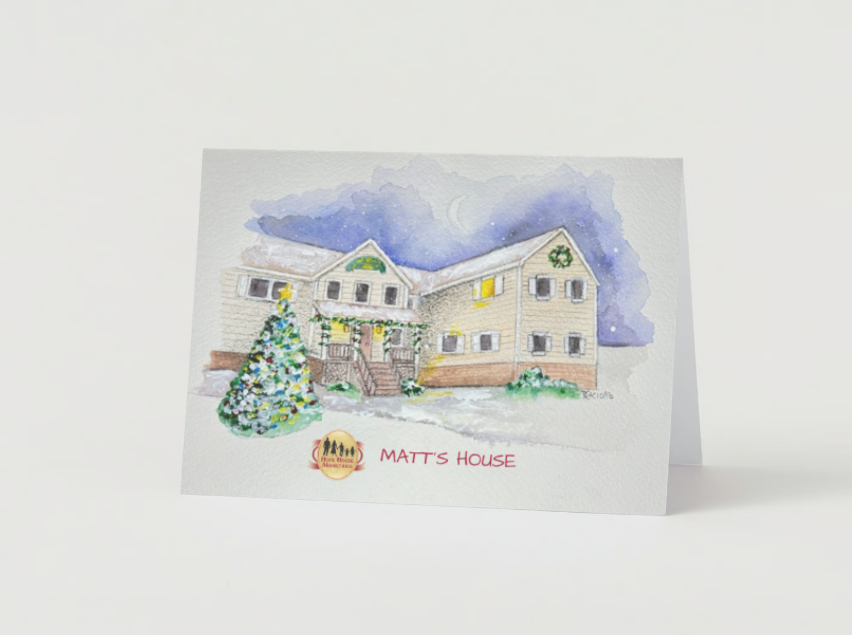 Watercolor holiday greeting card with an illustration of a house decorated with holiday wreaths and garlands, a Christmas tree, and a night sky with a crescent moon. Text reads "Matt's House".