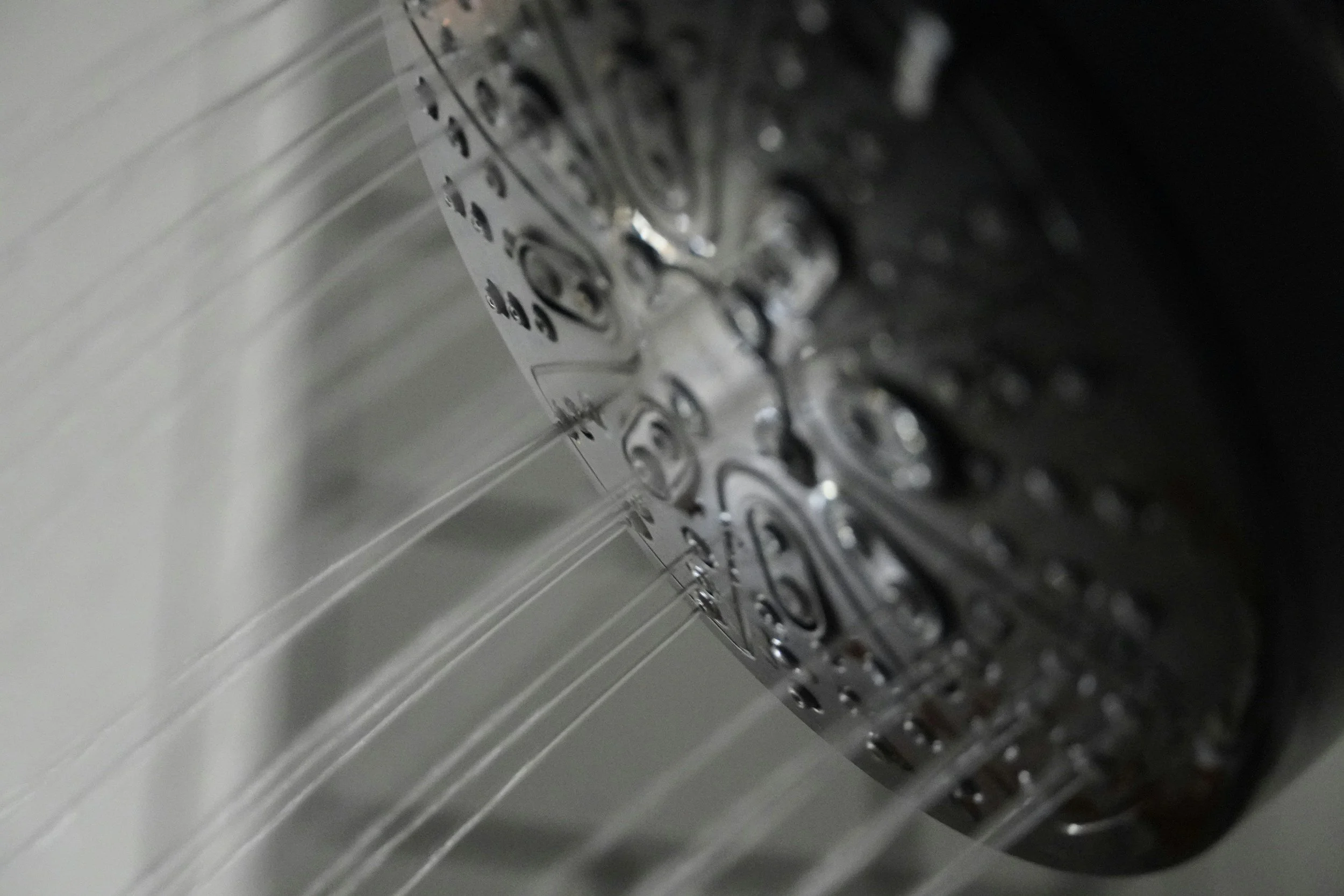 Close-up of the interior of a metallic washing machine drum with water jets.